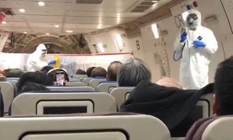Tiếp viên trên chuyến bay rời Vũ Hán trong trang phục bảo hộ. Ảnh: New York Times.