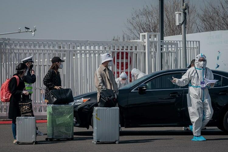 Các nhân viên y tế hướng dẫn những hành khách về từ nước ngoài tại trung tâm triển lãm quốc tế Tân Hoa gần sân bay Bắc Kinh hôm 16/3. Ảnh: AFP