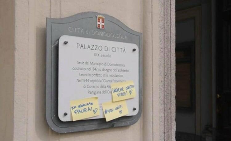 Những thông điệp kêu gọi đoàn kết và động viên người dân được dán ở bảng hiệu của Toà thị chính thành phố Domodossola hôm nay. Ảnh: Stella Vũ