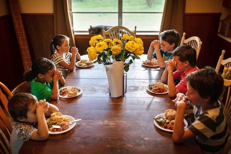 Các con của Mossbarger cầu nguyện trước khi ăn. Ảnh: NYTimes.