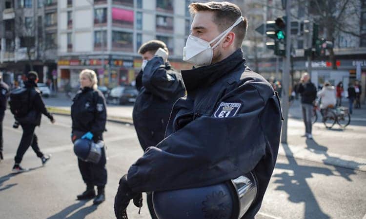Cảnh sát đeo khẩu trang khi giải tán cuộc tuần hành tự phát tại quận Kreuzberg của thủ đô Berlin, Đức ngày 28/3. Ảnh: AFP.